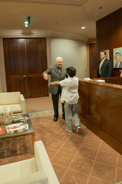 Carter rushes to hug the former President.