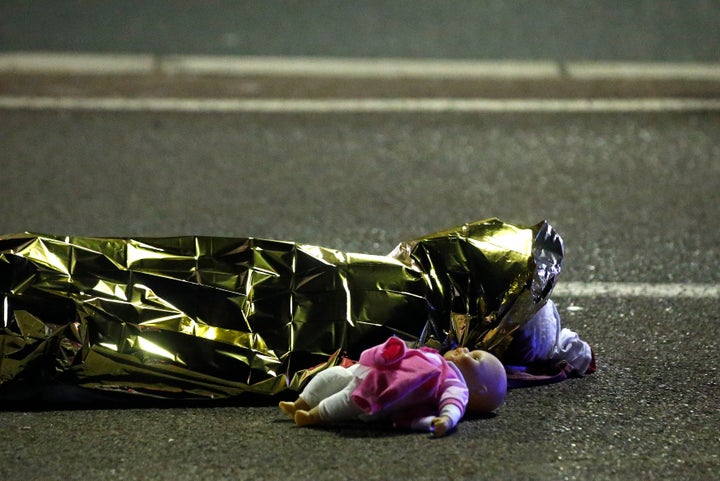<strong>The body, covered in a body bag, next to a child's doll</strong>
