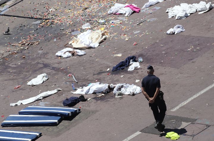 French gendarmes walk past clothes and mattresses at the site of the deadly attack.