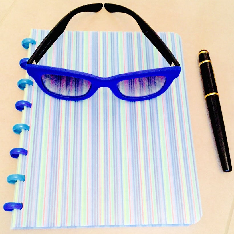 Exceptional spectacles on a notebook near pen