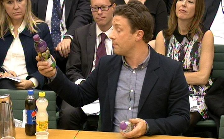 Oliver showing MPs the amount of sugar in soft drink