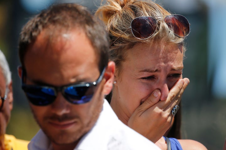 Individuals react near the location where a truck ran into a crowd of people celebrating the Bastille Day national holiday, which took place on July 14.