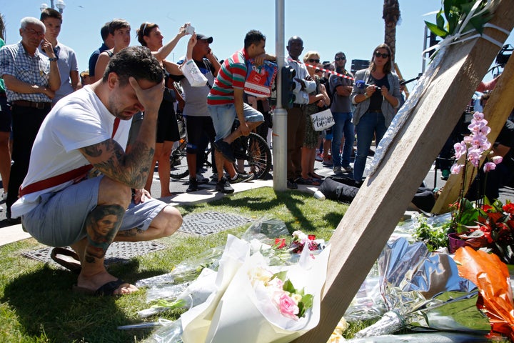 A man reacts near the scene where a truck ran into a crowd at high speed killing scores and injuring more who were celebrating the Bastille Day national holiday, in Nice, France on Thursday.