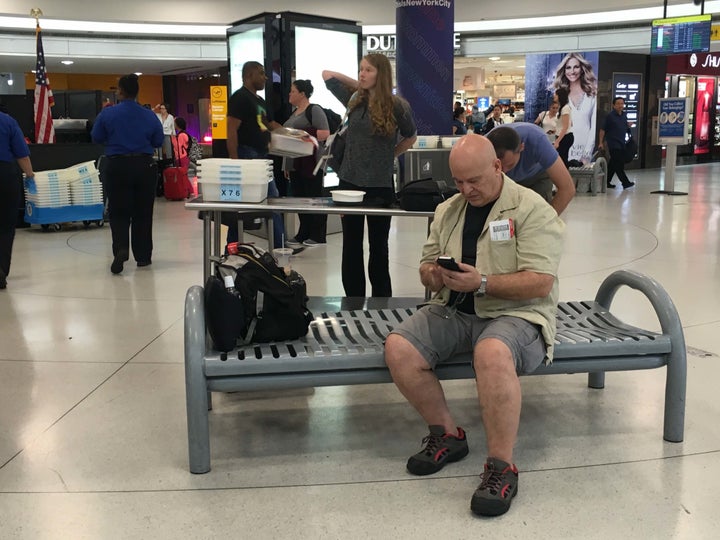 Chris Sassi of New York checks his phone for updates while awaiting news on his flight to Istanbul.