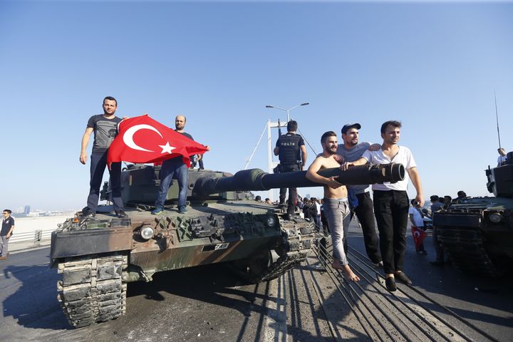 People pose near a tank after troops involved in the coup surrendered on the Bosphorus Bridge in Istanbul.