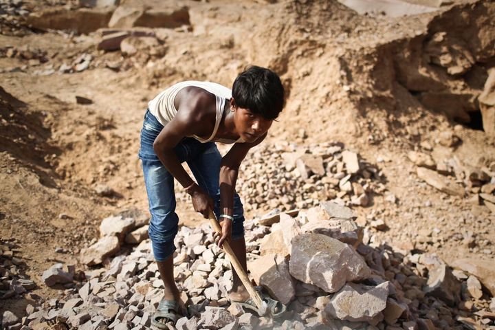 A teenage boy breaks rocks at a quarry in India