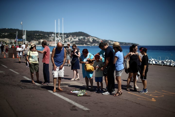 People gather around a spot where a person was killed on the Promenade des Anglais.