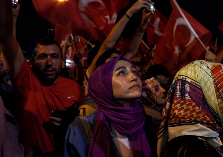 A woman looks up during a pro-government rally in central Istanbul's Taksim square, Saturday, July 16, 2016.