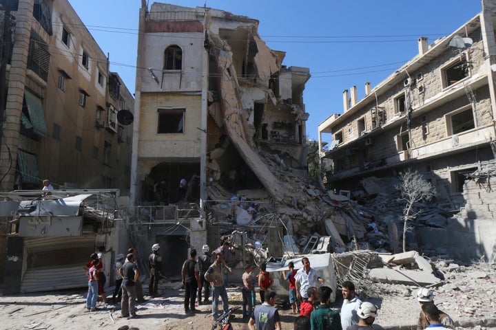 Men look for survivors inside a damaged building after an airstrike on Aleppo's rebel held Saif al-Dawla district, Syria July