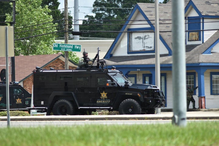 Officers with the East Baton Rouge Sheriff's Office search an area near the Hammond Aire Plaza, where Sunday's shooting took place.