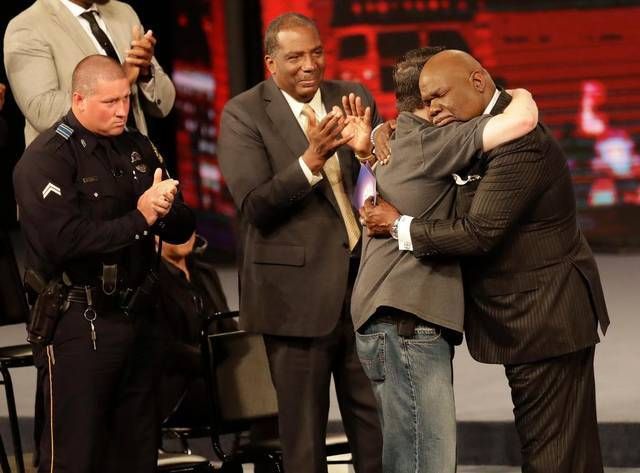 Bishop T.D. Jakes, right, embraces a first responder during a memorial service to the five police officers killed last week in Dallas.
