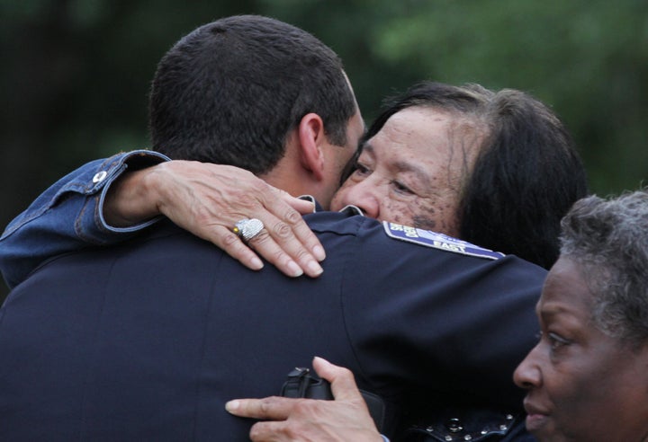 A police officer is embraced after a vigil for the fatal attack on Baton Rouge policemen, at a church in Louisiana, July 17, 2016.