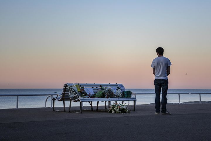 A man looks at a tribute laying on a bench near where a person was killed on the Promenade des Anglais on July 17, 2016.