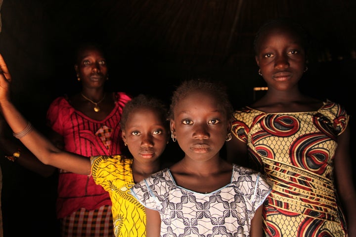 A woman and her daughters stand in their home, in the village of Cambadju, Guinea-Bissau. Their village is the first in the country to renounce FGM.