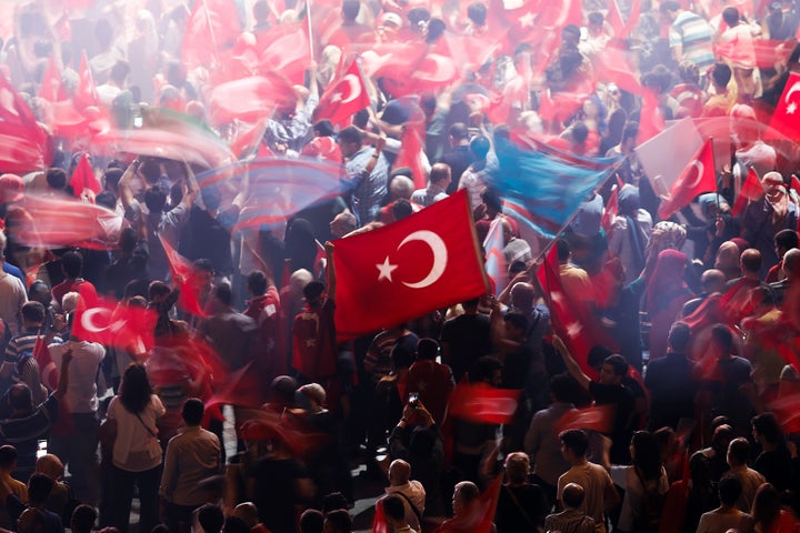 Supporters of Turkish President Recep Tayyip Erdogan wave Turkish national flags during a pro-government demonstration on Tak