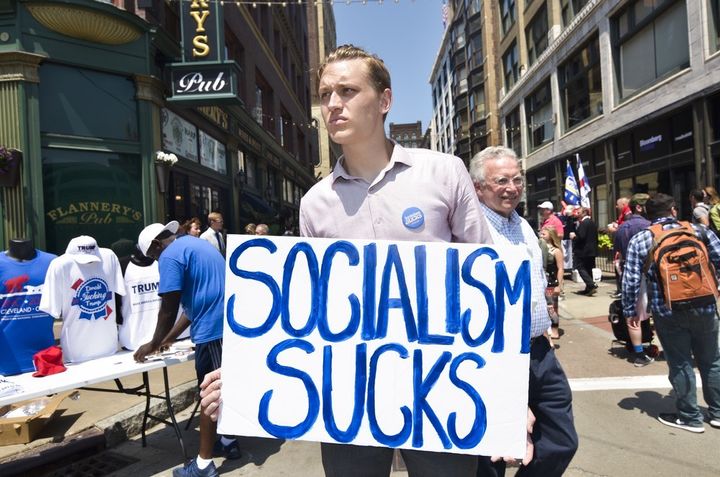 SOCIALISM SUCKS guy is all over Cleveland this week, dressed in a Calvin Klein shirt and tasteful pants and rocking half a man bun. He also had braces on. I’ve paid for braces, kid. In full. As far as I’m concerned, socialism with a solid orthodontia plan can’t come soon enough.