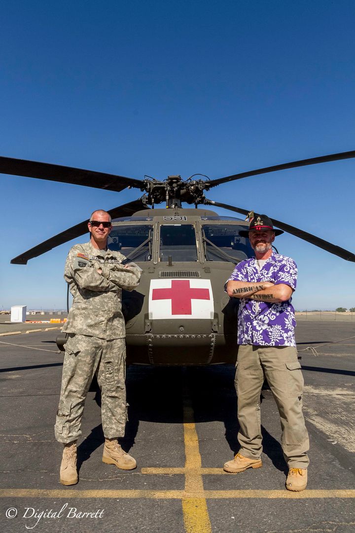 Chief Warrant Officer 3 Scott St. Aubin and Staff Sgt. Emmett Spraktes (Ret) stand in front of a UH-60L Black Hawk MEDEVAC helicopter