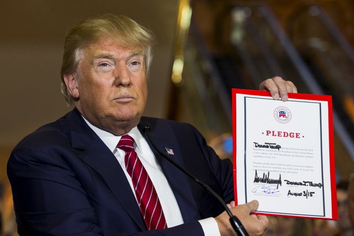 Trump shows off the pledge he signed at the request of Republican National Committee chairman Reince Priebus last year. Trump this spring disavowed the pledge because he said the RNC was mistreating him. He is now citing the pledge and demanding that his former rivals endorse him.