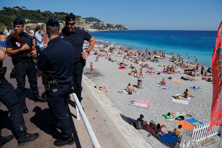 French CRS police patrol on the walkway above a public beach with sunbathers as security measures continue after the July 14 Bastille Day truck attack. 