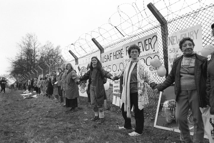 Women link hands at the Greenham Common Cruise Missile base during a demonstration marking the 6th anniversary of NATO's decision to deploy US Cruise and Pershing missiles in Europe