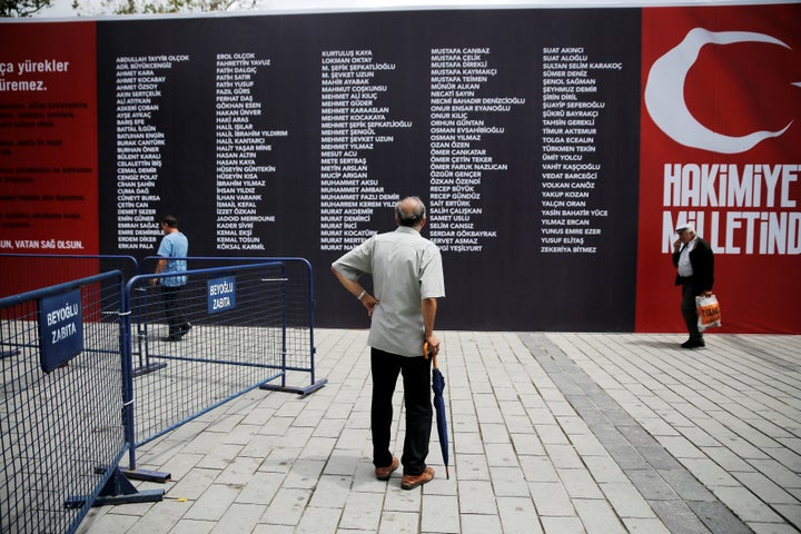 A man reads a banner with the names of civilians and policemen who were killed while resisting the coup attempt in Taksim square in Istanbul.