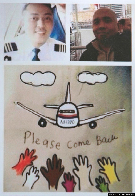 A photo of Zaharie Shah (top right) and co-pilot Fariq Abdul Hamid (top left) atop a poster appealing for the missing plane to ‘please come back’