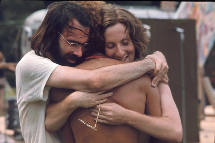 Three men attending the Woodstock music festival hug each other in August 1969. Woodstock co-founder Joel Rosenman wants GOP convention platform to include these values of community and love.