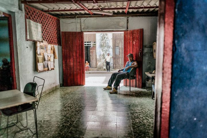 Sitting and waiting in the doorway of a boxing gym in Old Havana.