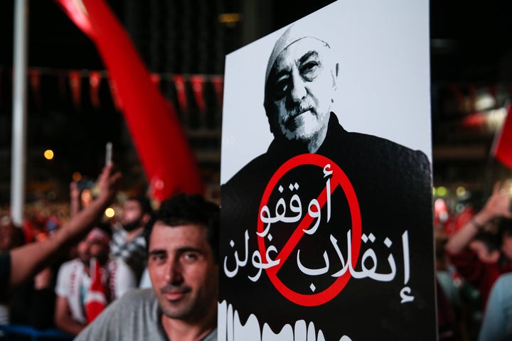 A man holds a sign showing Fethullah Gulen that reads "Take your hands off Turkish democracy" in Istanbul on July 2