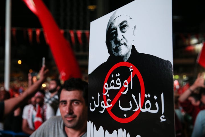 A man holds a sign showing Fethullah Gulen that reads "Take your hands off Turkish democracy" in Istanbul on July 20.