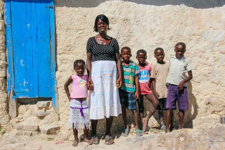 St. Abel Pierre stands in front of her house with some of her grandchildren.