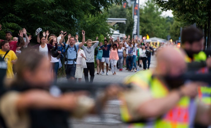 Police escorts evacuate people from a shopping mall in Munich on Friday following a shooting.