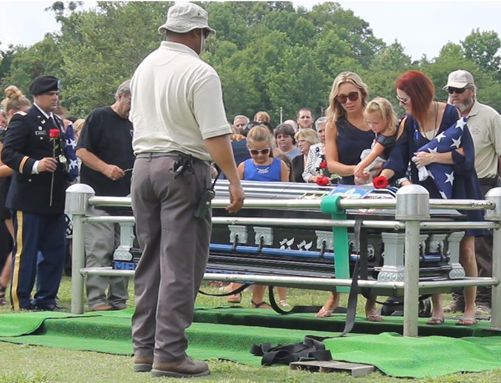 Dechia Gerald, wife of slain Baton Rouge police officer Matthew Gerald, right, stands with family members after placing a rose on her husband's casket.