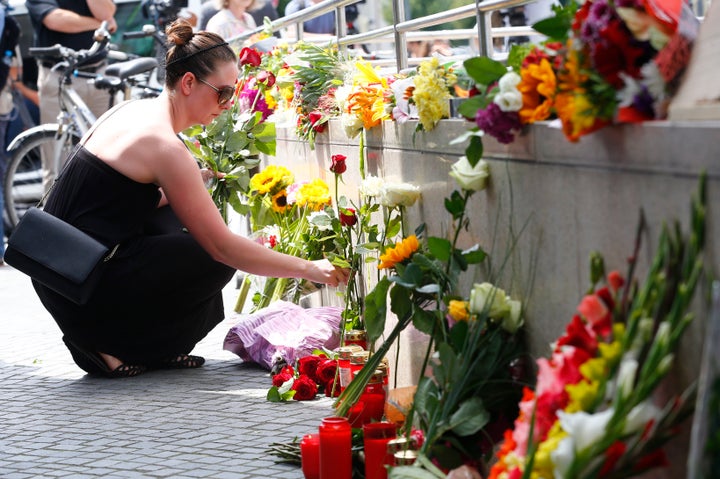 A women places flowers near the Olympia shopping mall, where yesterday's shooting rampage started, in Munich, Germany July 23, 2016.