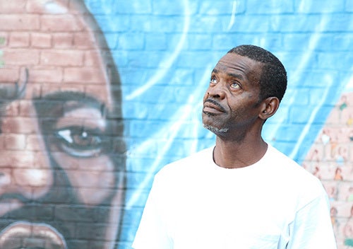 <i>Photo by Nancy A. Ruhling</i><br><strong>Ron touched up the Martin Luther King mural at Astoria Houses.</strong>