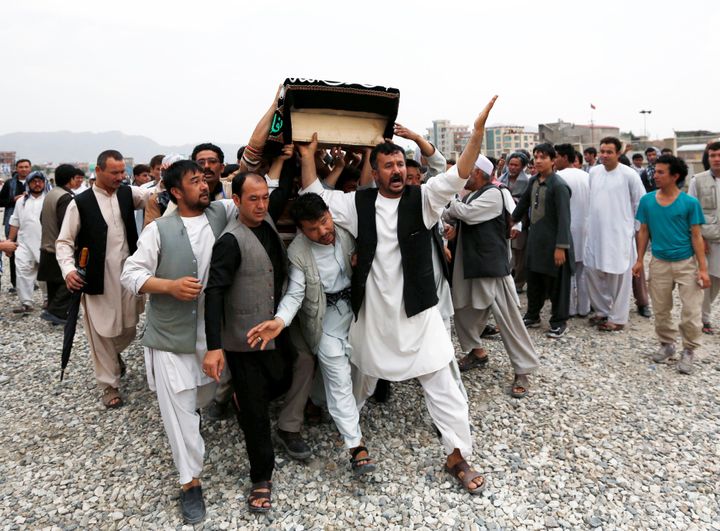 Men carry the coffin of a victim a day after a suicide attack in Kabul, Afghanistan July 24, 2016.