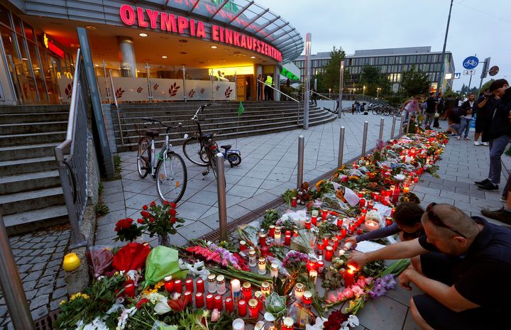 People light candles beside flowers laid in front of the Olympia shopping mall, where yesterday's shooting rampage started, in Munich, Germany July 23, 2016.