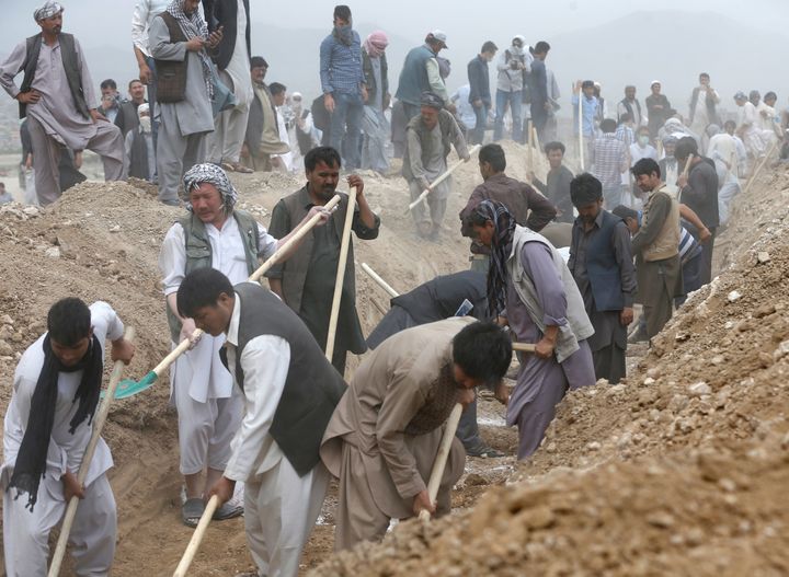 People dig graves for the victims of yesterday's suicide attack in Kabul, Afghanistan July 24, 2016