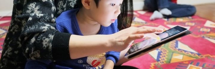 A child learning from an iPad