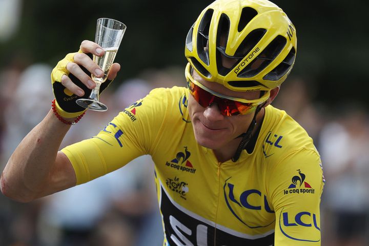 Yellow jersey leader Team Sky rider Chris Froome of Britain holds a glass of champagne.