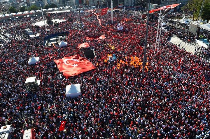 Thousands of supporters of various Turkish political parties hold Turkish flags and pictures of Mustafa Kemal Ataturk, t