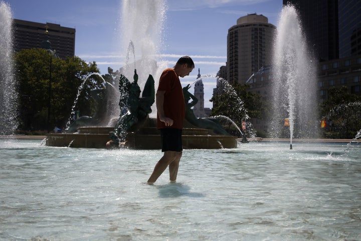 A man cools off by walking through a fountain in the Center City neighborhood in Philadelphia.