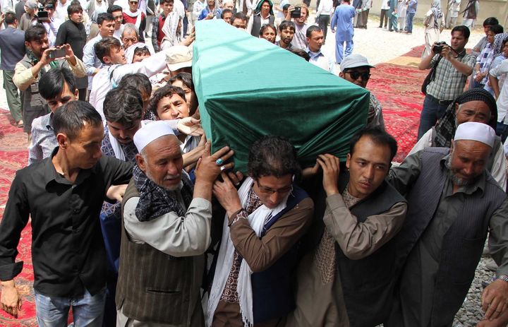 Afghan Shiites carry the coffin of a victim killed when a suicide attacker detonated explosive belts at a mass demonstration over the weekend.