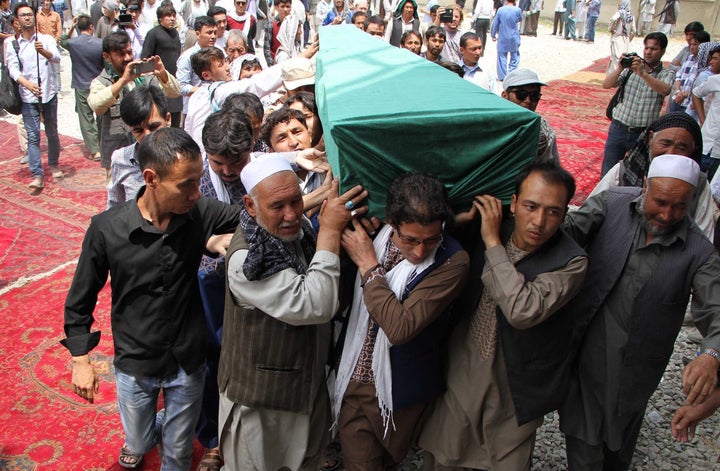 Afghan Shiites carry the coffin of a victim killed when a suicide attacker detonated explosive belts at a mass demonstration over the weekend.