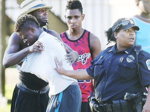 People comfort one another Monday at the scene of the shooting in Fort Myers, Florida.