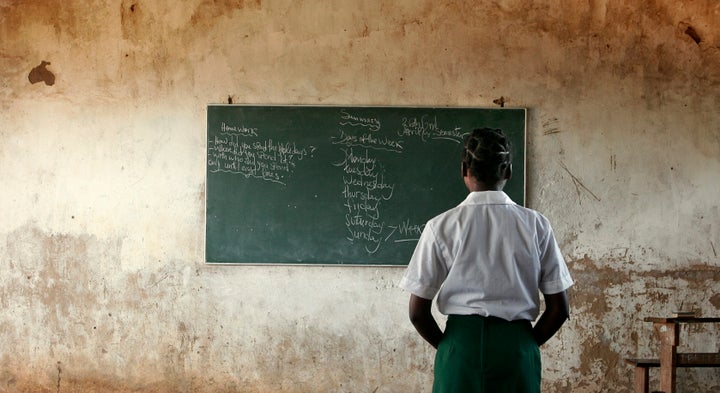 A young girl reads the day's lessons at a school near Xia Xia, Mozambique on April 26, 2005. Chi