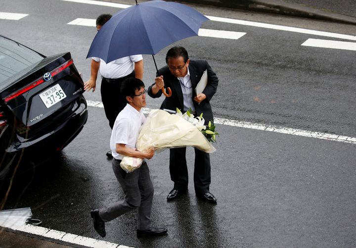 A prefecture government staff member carries flowers to mourn victims of the attack