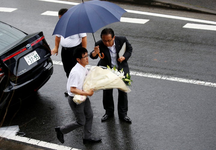 <strong>A prefecture government staff member carries flowers to mourn victims of the attack</strong>