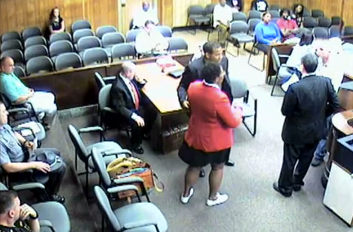 In this screenshot of security footage, attorney Andrea Burton is being taken into custody by bailiffs after refusing to remove her Black Lives Matter pin in court.