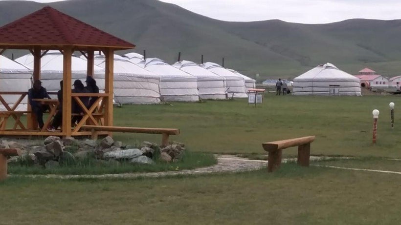 Tourists lounge in a <i>ger</i> camp pavilion